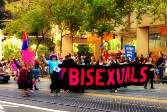 Parade participants carrying a large bisexuals banner