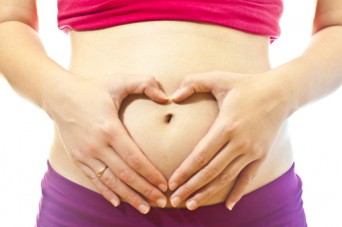 Hands making heart on pregnant stomach