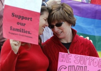 Lesbian partners embracing with pro-Civil Union signs