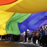 Gay pride celebrants with large rainbow flag
