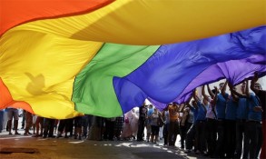 Gay pride celebrants with large rainbow flag