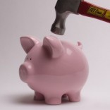 Breaking a piggy bank with a hammer