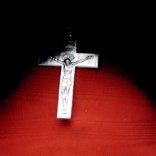 Small cross on wooden background