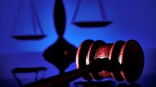 Gavel and legal scales with blue background