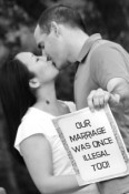 Biracial couple kissing with sign "our marriage was once illegal too." Photo by Jodi Rives Meier for Kiss4Equality.org
