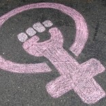Chalk drawing of a circle with a women's symbol in a fist
