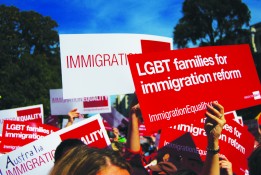 Protestors holding signs for LGBT immigration reform