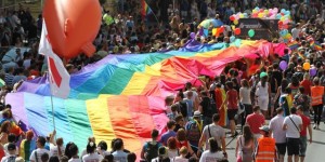 Celebrants in Prague Pride parada carry rainbow flag