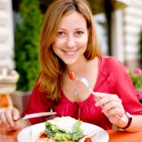 Smiling woman eating a salad